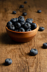 bowl of blueberries on wooden background with copy space