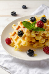 Waffles with fresh blueberries for breakfast on white table