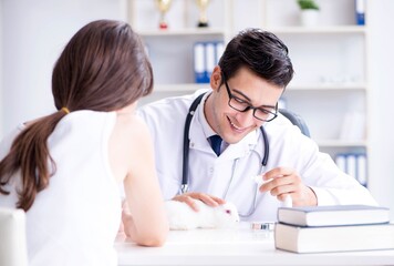 Fototapeta premium Woman with pet rabbit visiting vet doctor