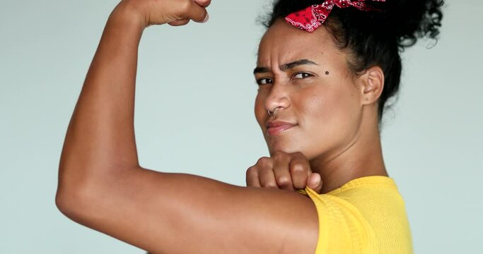 African American feminist woman posing to camera doing we can do it gesture with arm