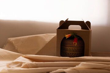 Planta suculenta con flor roja dentro de una caja envuelta para regalo. Caja de cartón en material ecológico con planta en maceta decorada con dibujos orgánicos