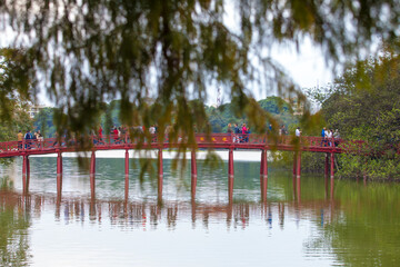 Hanoi, Vietnam - October 21, 2019 : Hanoi red bridge. The wooden red painted bridge over the Hoan Kiem Lake connects the shore and the Jade Island on which Ngoc Son Temple stands.