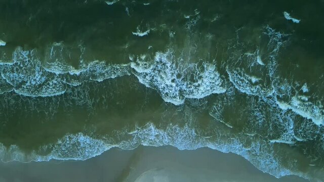 Top-down View Of A Blue  Waves Washing Up On The Sandy Shore Of Plaza Karwia Beach In Summer Near The Seaside Village Of Karwia In Poland.  -aerial drone shot