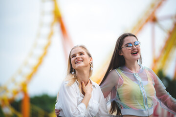 Cheerful diverse people hurting in the theme park, group of friends having fun and relaxing at...