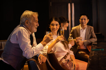 Cheers! Group of people cheering with champagne flutes in pub interior background