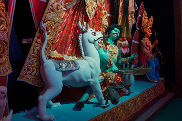 Idol of Lion killing Mahishasura or Asura, at decorated Durga Puja pandal at feet of Durga idol,...