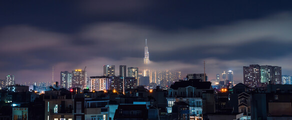 Spectacular view of a landmark 81 skyscraper sky in mist and clouds at Saigon at night in Ho chi minh city, Vietnam