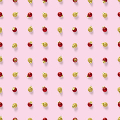 Seamless pattern with red and gold Christmas decorations on pink background. background made from balls. Christmas red ornaments Seamless pattern.
