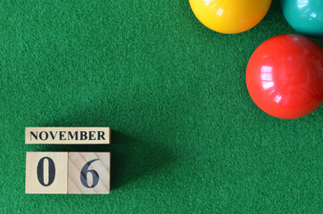 November 6, number cube with balls on snooker table, sport background.