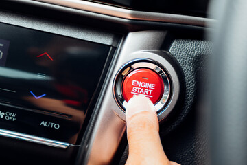 Finger about to touching and press button function start and stop luxury car engine in the...