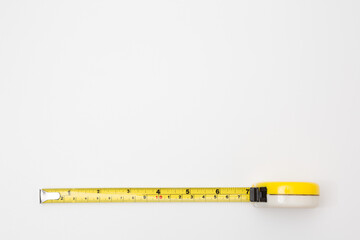 Yellow tape measure on white background  and copy space