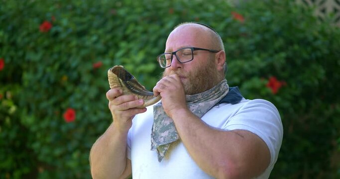 Jewish man blowing the Shofar in Rosh Hashanah during religious ritual, 4K