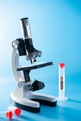 microbiologist with a tube of biological sample contaminated by Coronavirus with label Covid-19