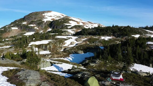 Aerial Reveal Of Tents On Top Of A Mountain