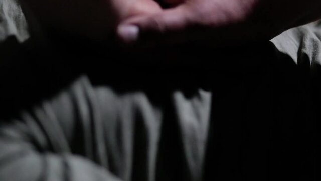 Close-up hands are pressing on the chest, doing artificial respiration. Light falls from above, forming harsh shadows. The camera moves from bottom to top, then back.
