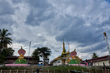 Naklejka premium Inle Lake is in the Shan Hills of Myanmar. At its southwestern edge, Phaung Daw Oo Paya is a tiered pagoda with gilded Buddha statues. In the hills, near the market town of Indein, the stupas of Shwe 