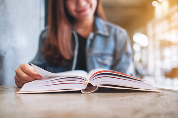 Closeup image of a young woman sitting and reading book