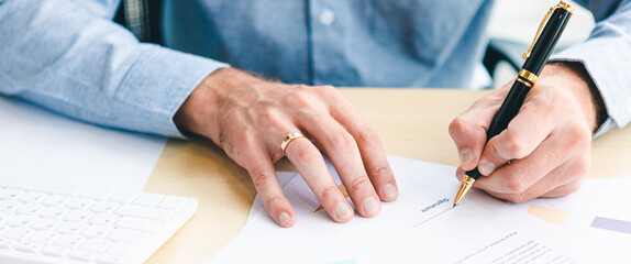 Close up of hand young businessman signing a contract on document paper about the financial business loan working in office. Panoramic web banner on background with copy space. Model business concept.