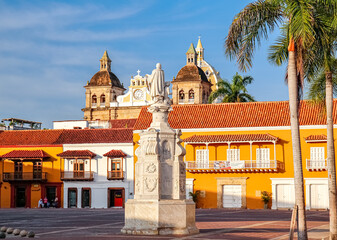 View to a plaza with a statue, historical buildings, church towers and palm trees, Cartagena,...