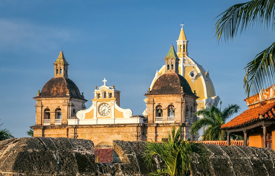 Close up view over roofs in Cartagena with statue and bell towers of church San Pedro Claver
