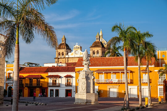 View to a plaza with a statue, historical buildings, church towers and palm trees, Cartagena, Unesco World Heritage - Powered by Adobe