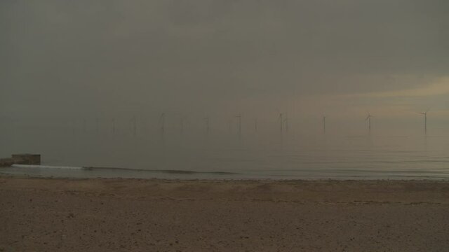 An offshore windfarm in North East England at sunrise.