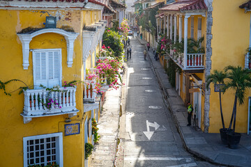 Fototapeta na wymiar High angle view of a narrow street with historic houses with decorated balconies in sunshine, Colombia, Unesco World Heritage 