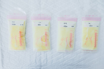 Above view of breast milk frozen in storage bags for newborn baby on white background. Breastfeeding or early childhood development concept. Top-down