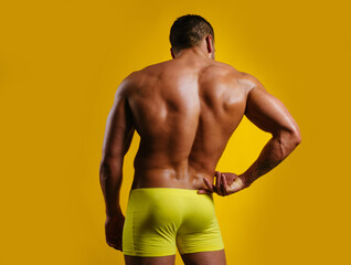 Naked man posing in the studio. Topless male model. Bare torso. Bodybuilder and strip theme. Male...