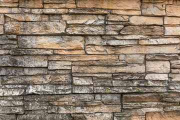 Gray-beige decorative stone on the wall. Background. Space for text.