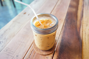 Iced coffee in cup on a wooden table at the cafe. Cold espresso in the coffee shop. Beverage glass frozen in the restaurant. Food sales busy interior decoration vintage.