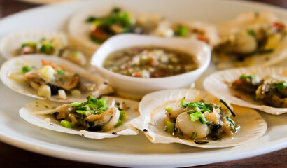 Closeup of seared scallops on white dish at the restaurant.