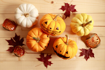 Halloween pumpkins with painted face on wooden table background.