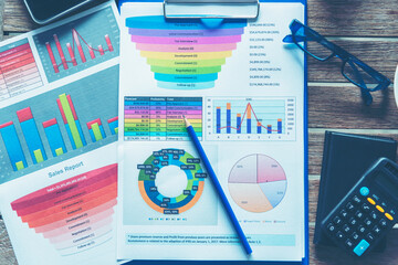 Office laptop business financial document chart and graph on wooden table with coffee cup. Flat lay notebook computer laptop on office desk. No people business graph chart mockup on business workspace