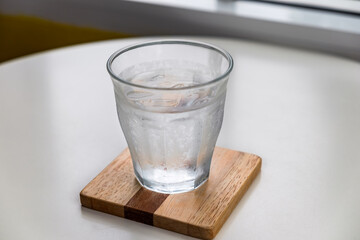 Glass of water cold on the table in the home. Natural beverage the best start to any morning in the restaurant or cafe.