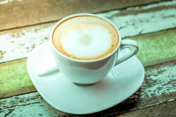 Above view of hot coffee cup on wooden table at the cafe background.