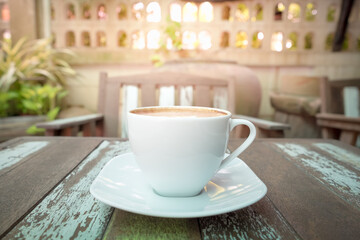 Front view of hot coffee cup on wooden table at the cafe background.