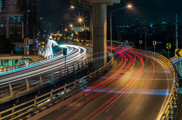 Fototapeta na wymiar Overpass of the light trails with Bangkok city background at night. Beautiful curves. Selective focus.