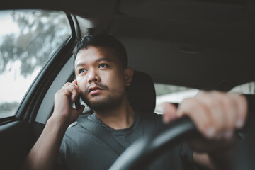 Asian man calling via smart mobile phone inside a car, close up. People lifestyle, social media communication concept. © Looker_Studio