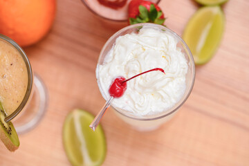 Summer drinks with fruit juice and ice. Refreshing summer beverages in different glasses over rustic wooden background