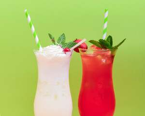 Summer drinks with fruit juice and ice. Refreshing summer beverages in different glasses over green background.