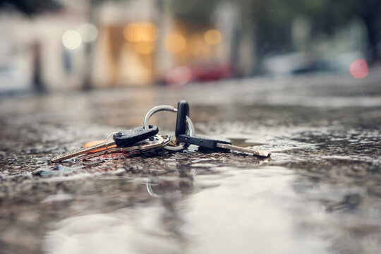 Set of lost keys on the ring on wet ground in the street