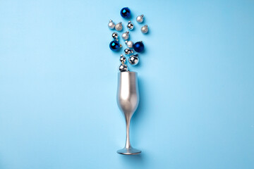 Champagne glass with Christmas balls flat lay