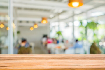 Wood table in front of group young friends come to meet and laughing enjoy in the cafe blur background. Brown wooden desk in front of crowd group talking in coffee shop. Empty counter in restaurant.