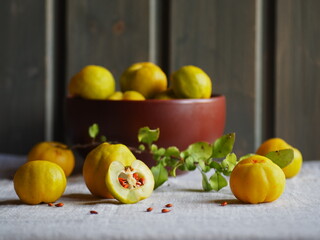 Quince fruit, brown clay bowl on a gray background