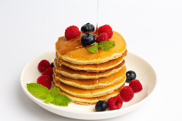 Delicious pancakes with raspberry and blueberry on White background