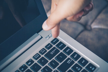 Closeup image of finger pushing button delete data on the laptop computer. Press keyboard on the...