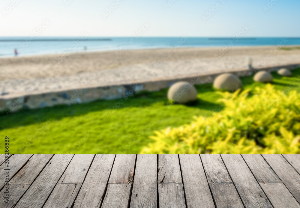 Wall mural image of rustic wood table in front of beautiful beach resort blurred background. brown wooden empty