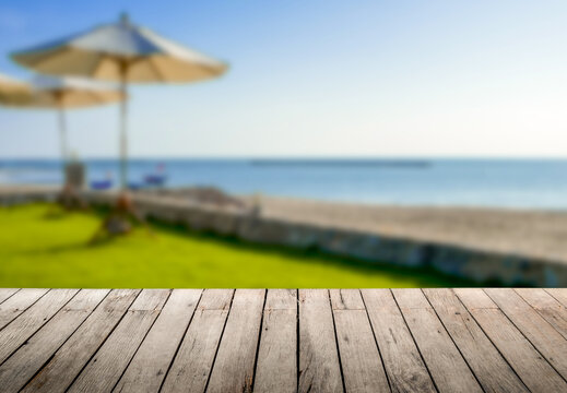Image of rustic wood table in front of beautiful beach resort blurred background. Brown wooden empty counter in front of the sea and outdoor spa.