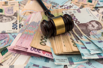wooden hammer on ukraine money as background. 500 and 1000 new uah grivna